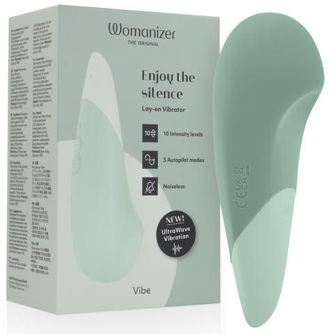 Womanizer Vibe vert sauge devant sa boîte, forme large et pointe arrondie avec panneau clair
