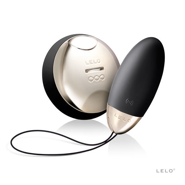 Œuf noir LELO Lyla 2 à extrémité argentée, posé devant sa télécommande ronde et sa boucle noire